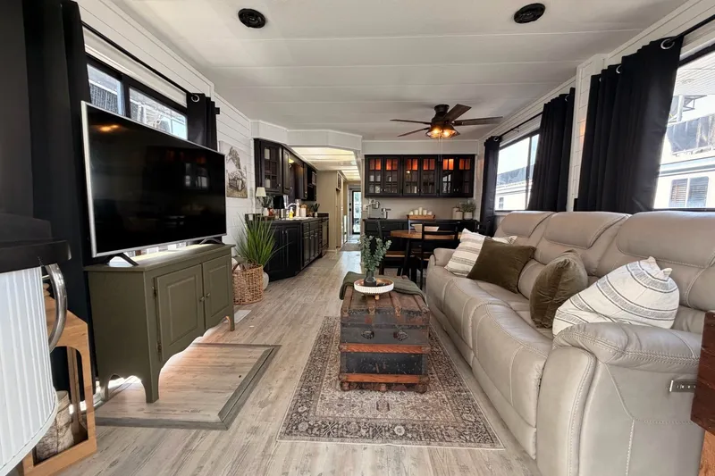 Slide: The Image of Cozy 1991 Leisure Time 14x63 interior with modern decor, featuring a sofa, TV, and dining area. - 13
