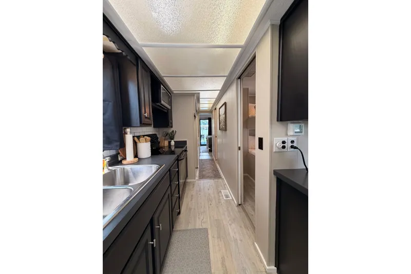 Slide: The Image of Narrow kitchen interior of 1991 Leisure Time 14x63 mobile home with modern decor. - 25