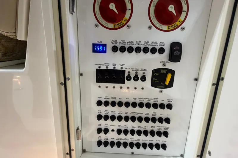 Slide: The Image of Control panel of a 2019 Pursuit DC 325 Dual Console boat, featuring switches and battery meters. - 38