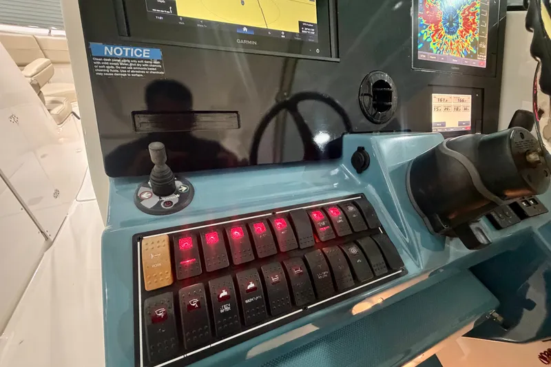 Slide: The Image of 2019 Pursuit DC 325 Dual Console dashboard with illuminated control switches and navigation screens. - 16