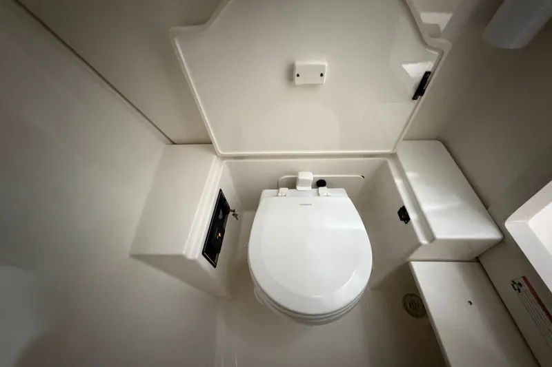 Slide: The Image of 2019 Pursuit DC 325 Dual Console boat bathroom with white marine toilet. - 37