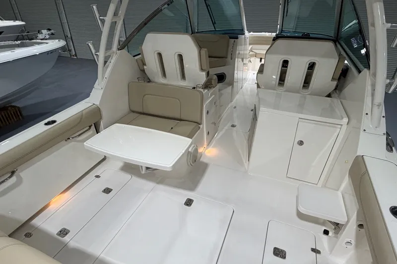 Slide: The Image of 2019 Pursuit DC 325 Dual Console boat interior with seating and table setup. - 28