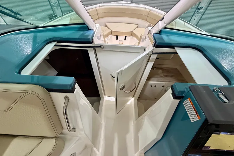 Slide: The Image of 2019 Pursuit DC 325 Dual Console interior with open storage compartments and seating. - 32