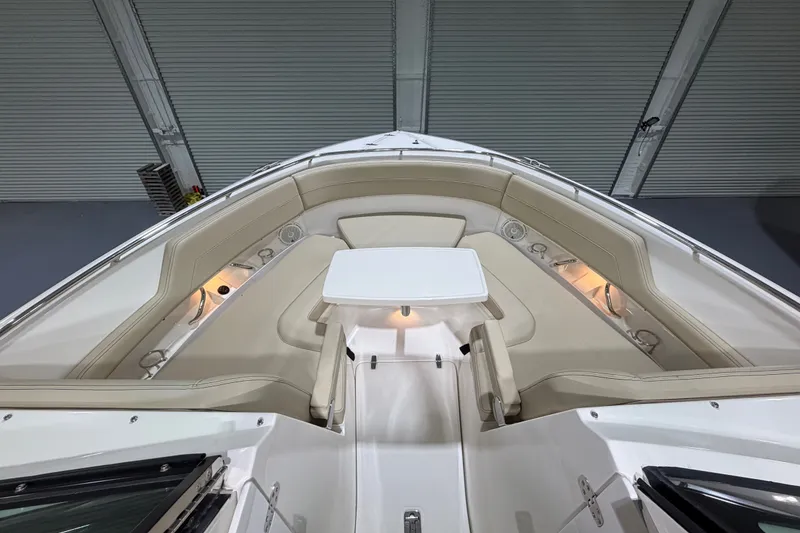 Slide: The Image of 2019 Pursuit DC 325 Dual Console boat interior with beige seating and white table. - 26