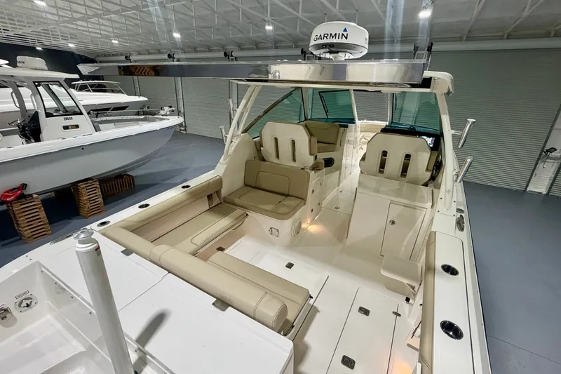 Slide: The Image of 2019 Pursuit DC 325 Dual Console boat interior with beige seating and Garmin radar. - 18