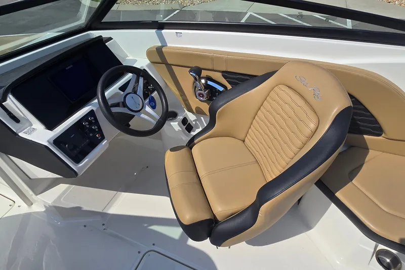 Slide: The Image of 2024 Sea Ray SPX 230 boat interior with tan and black captain's seat and modern dashboard. - 10