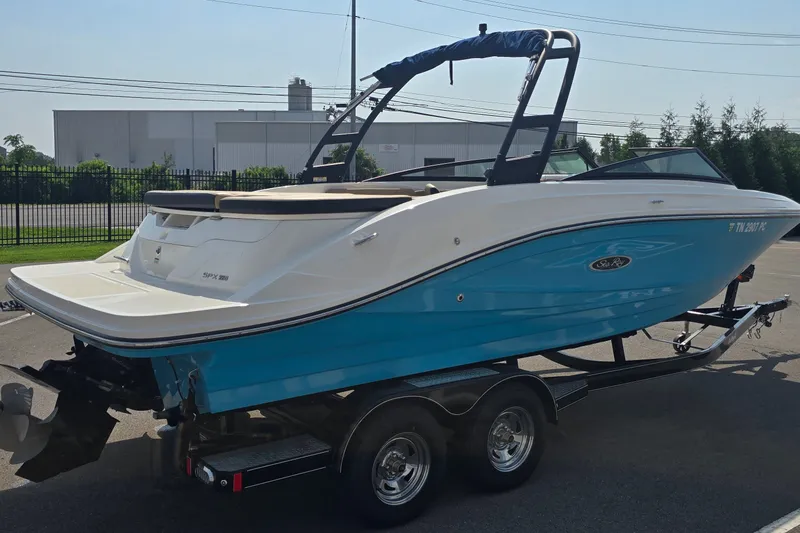 Slide: The Image of 2024 Sea Ray SPX 230 boat on trailer, blue and white design, parked outdoors. - 4