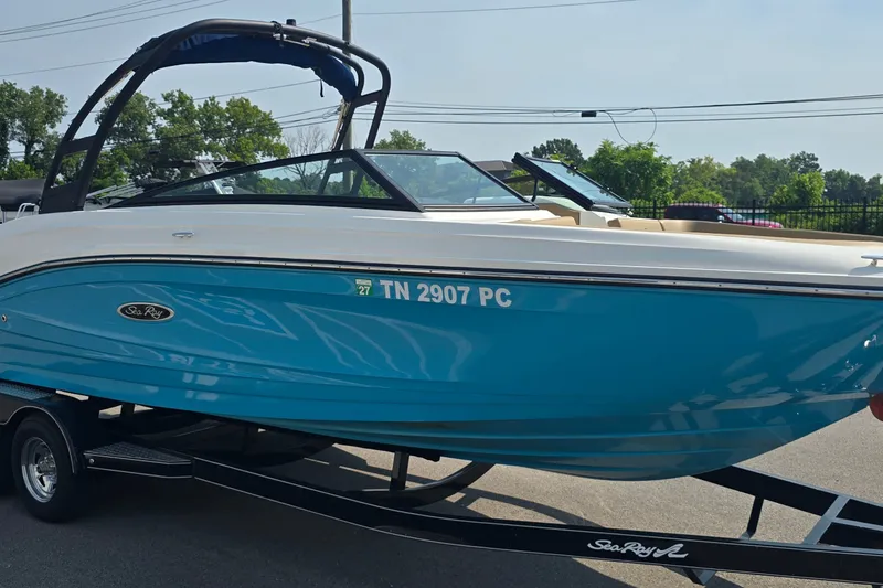 Slide: The Image of 2024 Sea Ray SPX 230 boat in vibrant blue on a trailer, parked outdoors. - 5