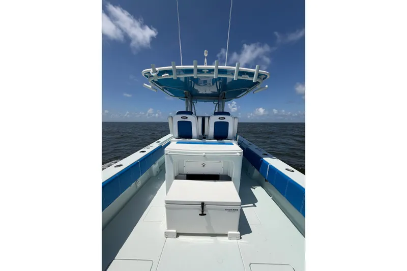 Slide: The Image of 2012 Contender 35 ST boat on open water, featuring blue and white seating and a T-top. - 21