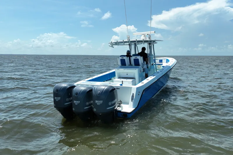 Slide: The Image of 2012 Contender 35 ST boat with triple Yamaha engines cruising on open water. - 7