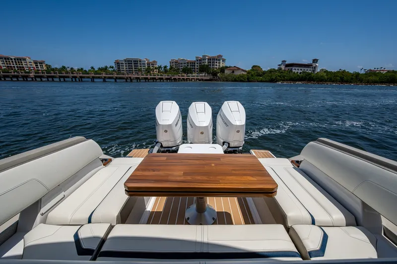 Slide: The Image of 2024 Tiara Yachts 38 LS with triple engines, luxurious seating, and scenic waterfront view. - 30