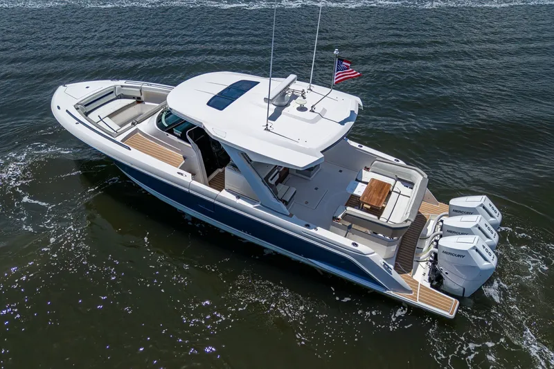 Slide: The Image of 2024 Tiara Yachts 38 LS cruising on water, featuring sleek design and triple Mercury engines. - 10