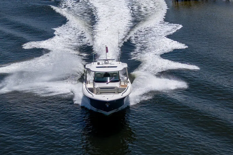 Slide: The Image of 2024 Tiara Yachts 38 LS cruising on water, creating dynamic wake patterns. - 11