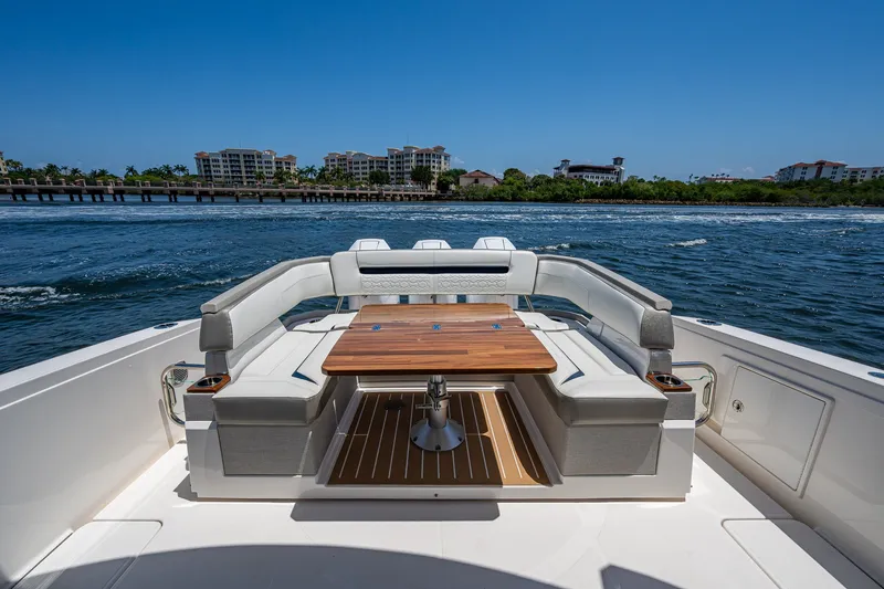 Slide: The Image of 2024 Tiara Yachts 38 LS luxury yacht deck with seating and table, ocean view. - 24