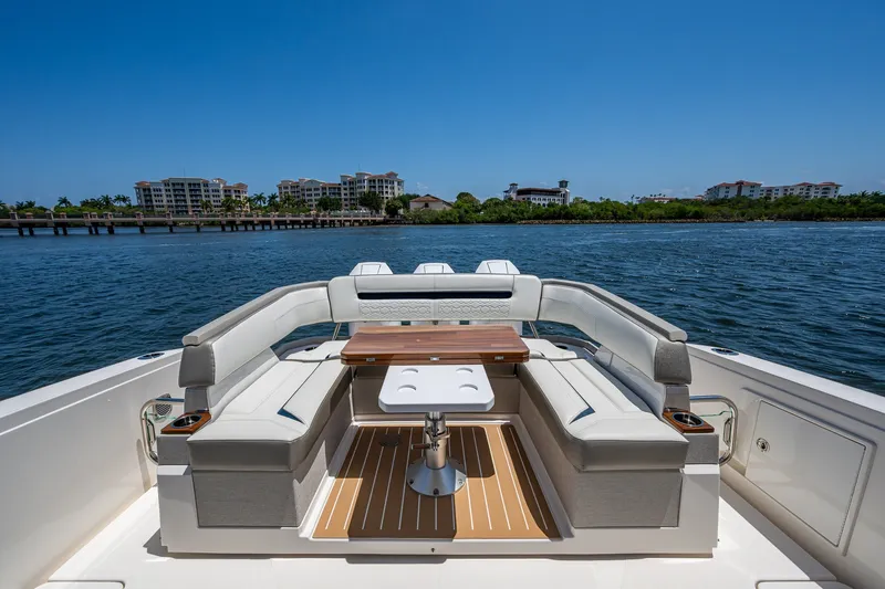 Slide: The Image of 2024 Tiara Yachts 38 LS luxury yacht deck with seating and table, overlooking serene waterfront. - 26