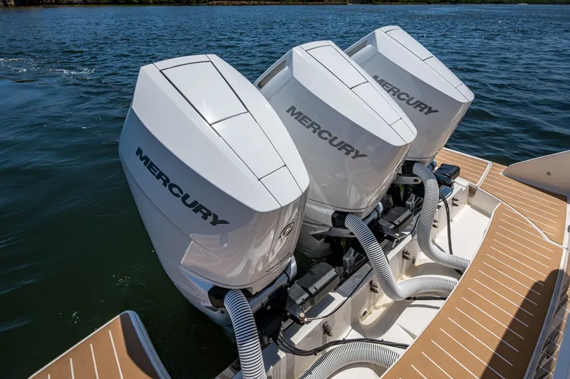 Slide: The Image of Triple Mercury outboard engines on a 2024 Tiara Yachts 38 LS, cruising on water. - 38