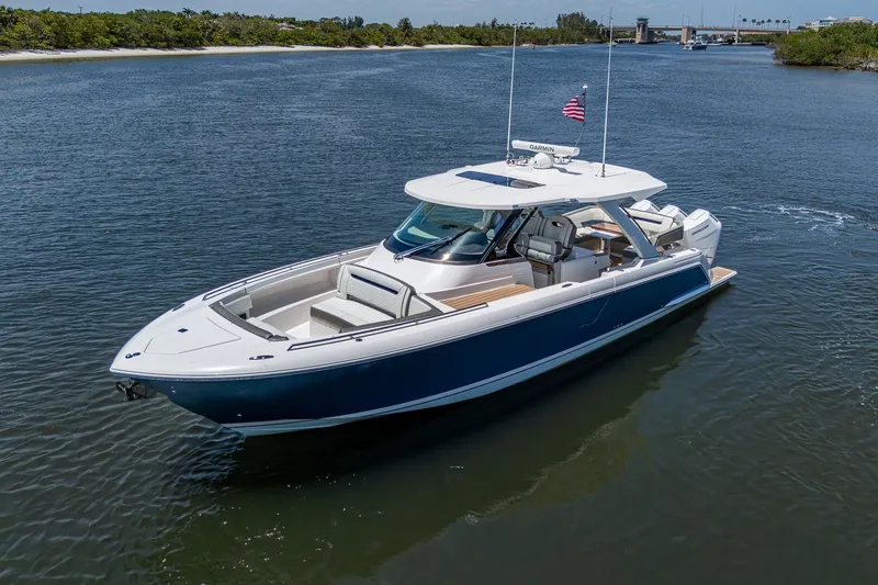 Slide: The Image of 2024 Tiara Yachts 38 LS cruising on a serene waterway, showcasing sleek design and luxury. - 2