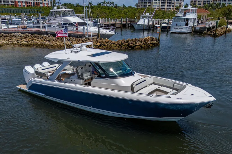 Slide: The Image of 2024 Tiara Yachts 38 LS luxury boat docked in a marina, showcasing sleek design. - 6