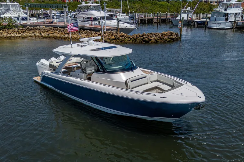 Slide: The Image of 2024 Tiara Yachts 38 LS luxury boat docked in a marina, showcasing sleek design. - 5