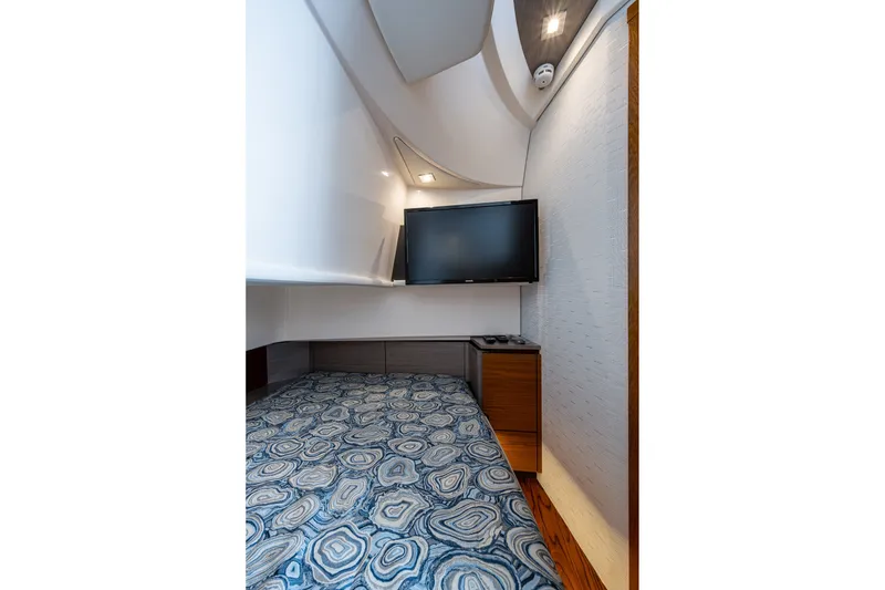 Slide: The Image of 2024 Tiara Yachts 38 LS cabin interior with patterned bedding and wall-mounted TV. - 44