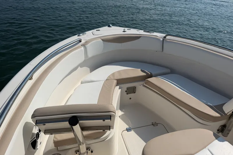 Slide: The Image of 2018 Robalo R222 Center Console boat interior with cushioned seating, on calm water. - 17