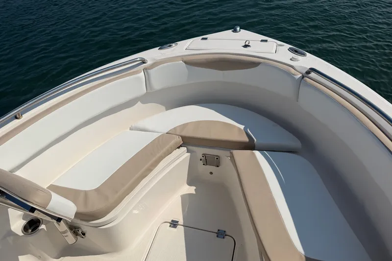 Slide: The Image of 2018 Robalo R222 Center Console boat interior with cushioned seating, on calm water. - 14