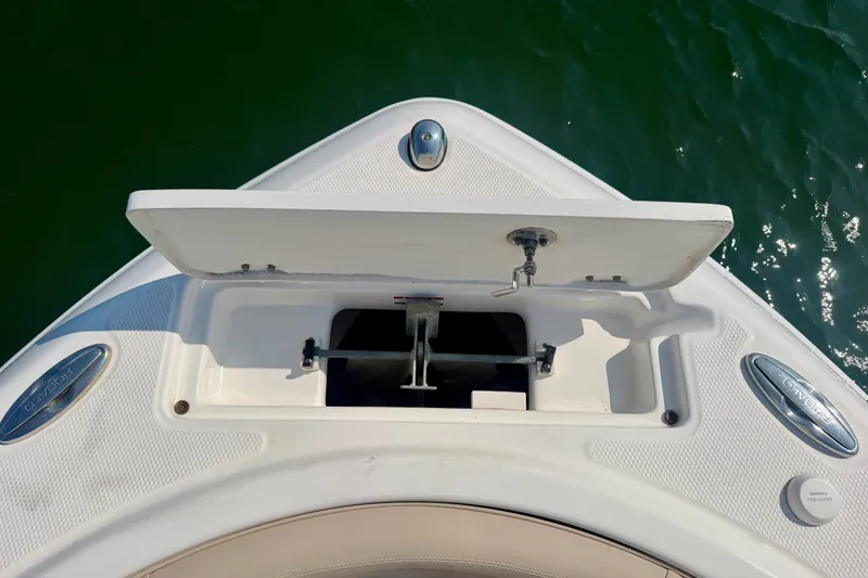 Slide: The Image of 2018 Robalo R222 Center Console boat anchor compartment open on calm water. - 18