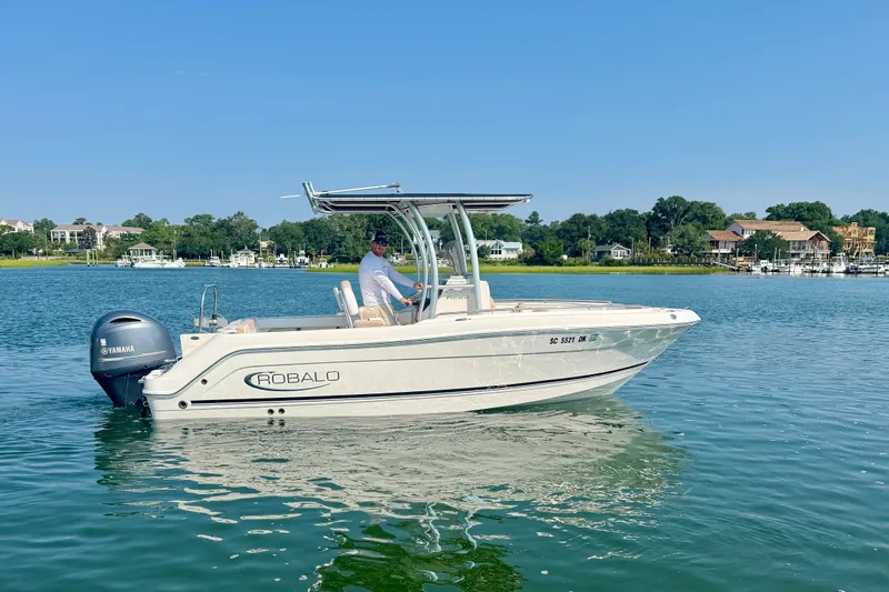 The Image of 2018 Robalo R222 Center Console boat on calm water with scenic background. - 1