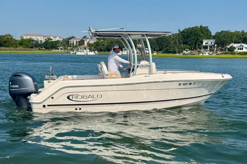 Slide: The Image of 2018 Robalo R222 Center Console boat cruising on a sunny day with scenic waterfront homes. - 7