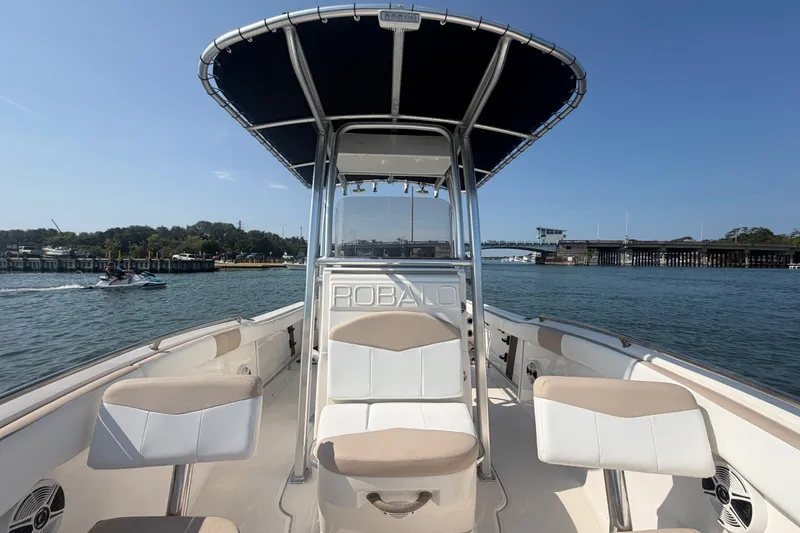 Slide: The Image of 2018 Robalo R222 Center Console boat on calm water, featuring a sleek design and spacious seating. - 20