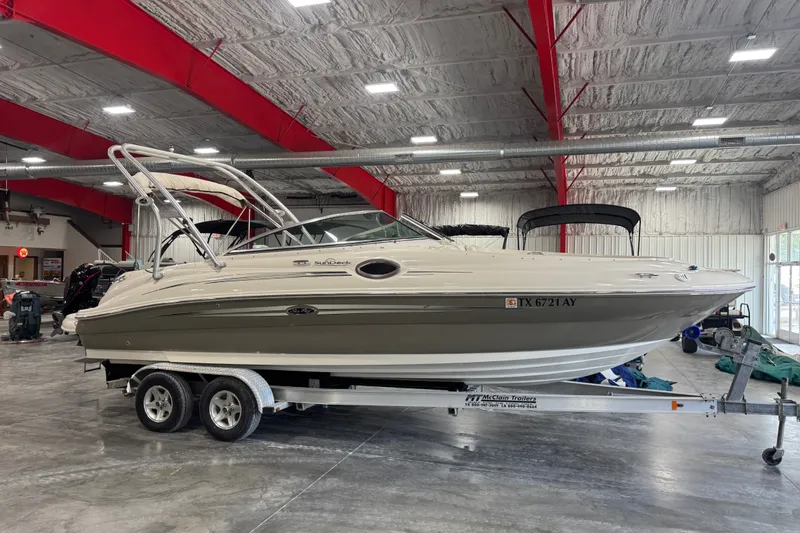 The Image of 2008 Sea Ray 240 Sundeck boat on trailer in indoor storage facility. - 1