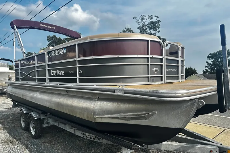 The Image of 2018 Berkshire Pontoon boat on trailer, named "Jenny Mama," under a clear sky. - 0