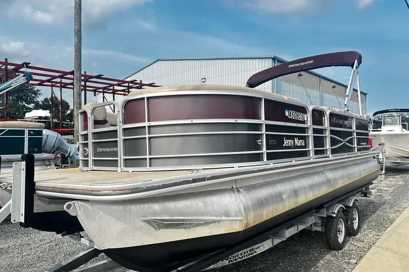 Slide: The Image of 2018 Berkshire Pontoon boat on trailer, parked outdoors near a marina. - 1