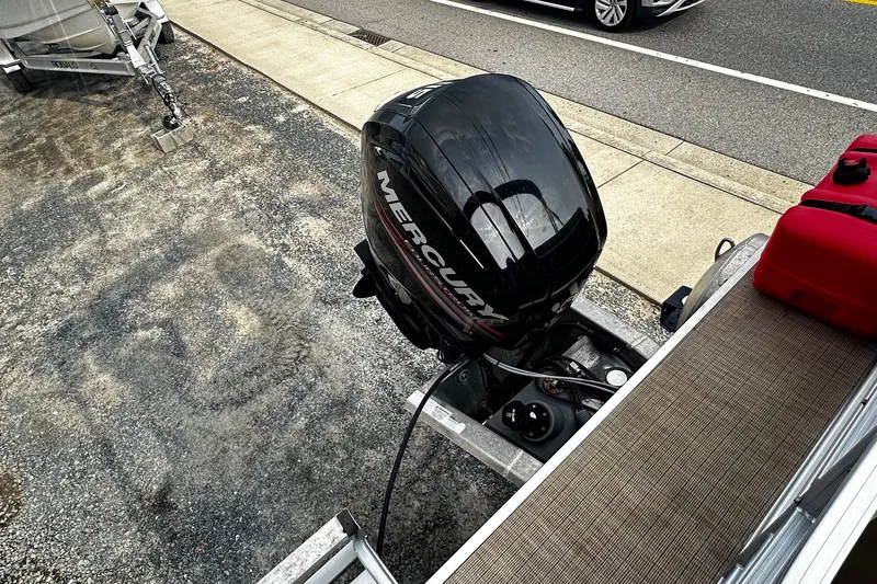 Slide: The Image of 2018 Berkshire Pontoon with Mercury outboard motor on a trailer, parked roadside. - 13