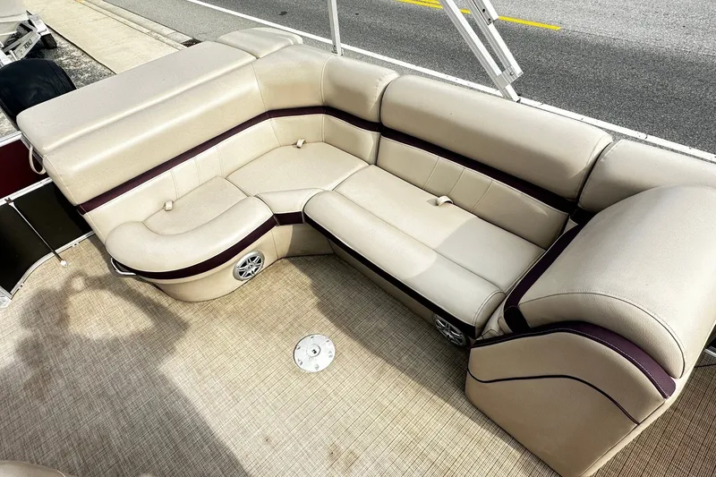 Slide: The Image of Luxurious seating on a 2018 Berkshire Pontoon boat, featuring beige upholstery and built-in speakers. - 9
