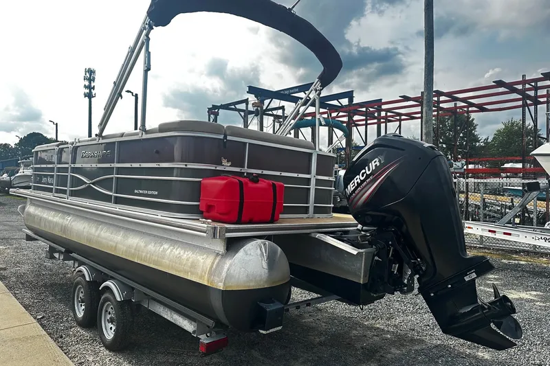 Slide: The Image of 2018 Berkshire Pontoon boat on trailer with Mercury outboard motor, parked outdoors. - 2
