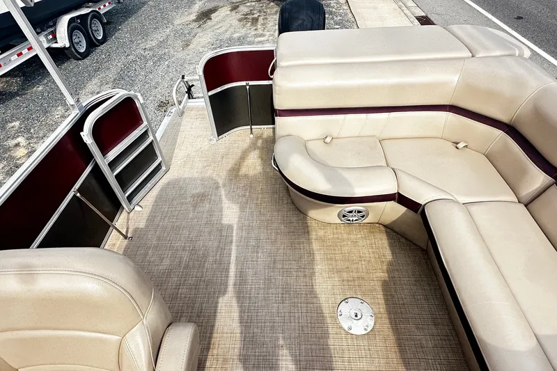 Slide: The Image of 2018 Berkshire Pontoon boat interior with beige seating and maroon accents. - 8
