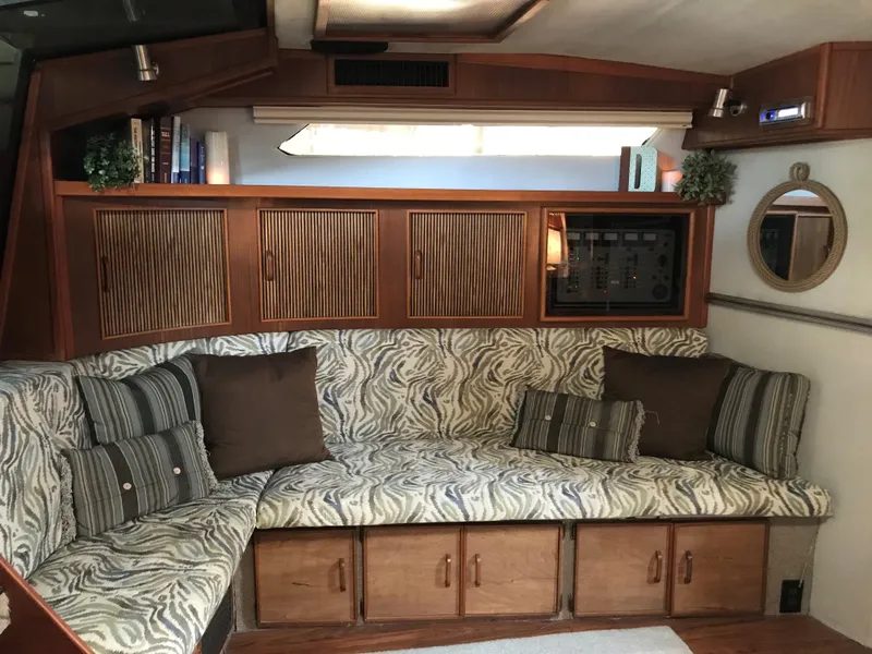 Slide: The Image of Interior of the 1987 Sea Ray 390 Express Cruiser with cozy seating and wooden cabinetry. - 14