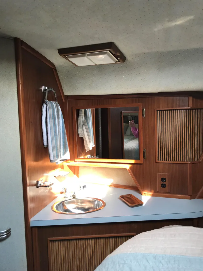 Slide: The Image of Interior of the 1987 Sea Ray 390 Express Cruiser with a sink and wood paneling. - 23