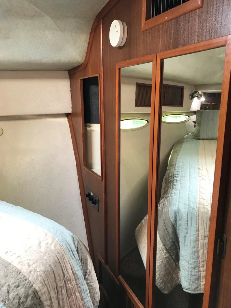 Slide: The Image of Interior of a 1987 Sea Ray 390 Express Cruiser with a mirror and bed. - 24