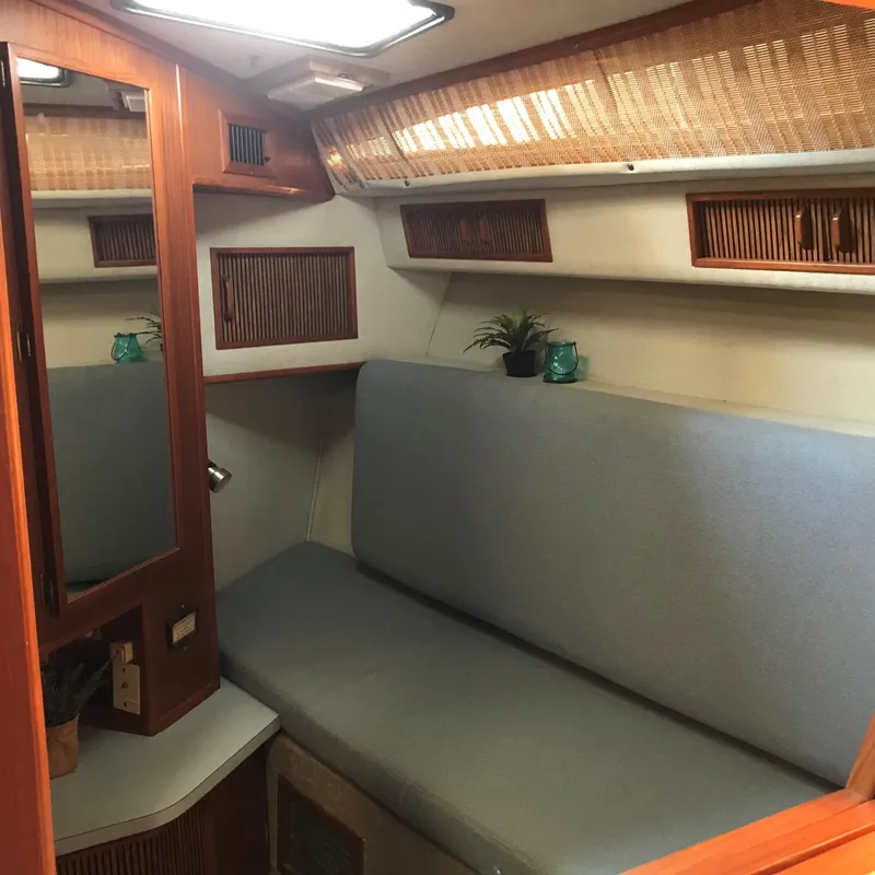 Slide: The Image of Interior of a 1987 Sea Ray 390 Express Cruiser with cozy seating and wooden accents. - 20