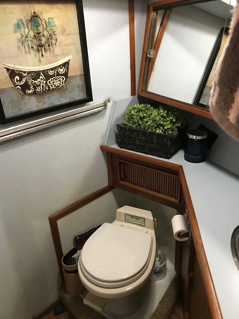 Slide: The Image of The image shows a boat bathroom with a toilet, mirror, and decorations. - 25