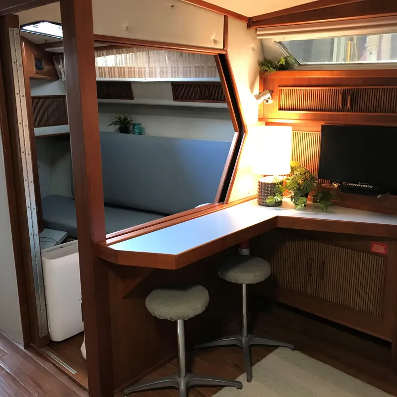 Slide: The Image of Interior of the 1987 Sea Ray 390 Express Cruiser with a desk and seating area. - 22