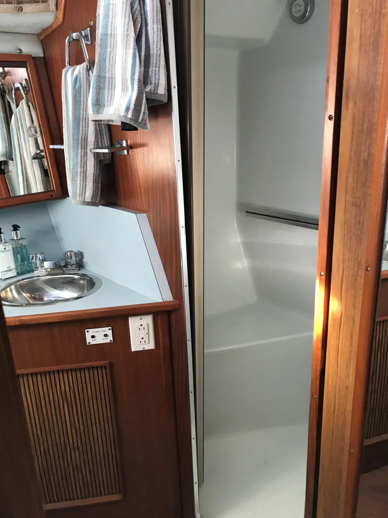 Slide: The Image of The image shows the bathroom of a 1987 Sea Ray 390 Express Cruiser with a sink and shower. - 26