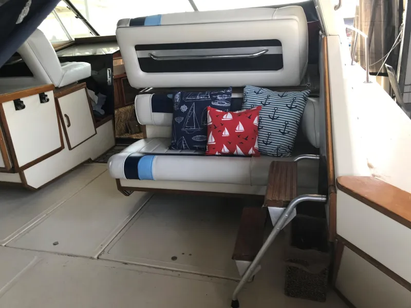 Slide: The Image of Interior of a 1987 Sea Ray 390 Express Cruiser with a bench seat and decorative pillows. - 13