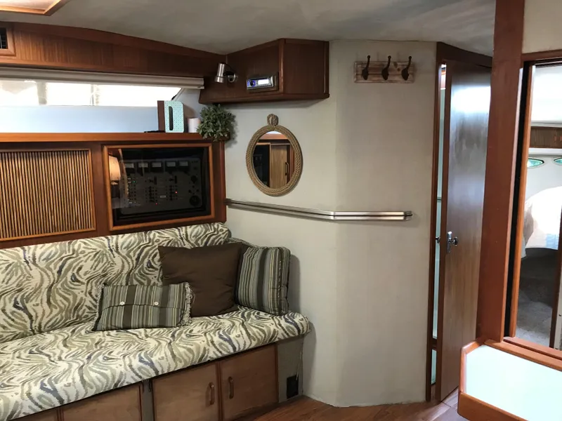 Slide: The Image of Interior of a 1987 Sea Ray 390 Express Cruiser with cozy sofa and wood accents. - 8