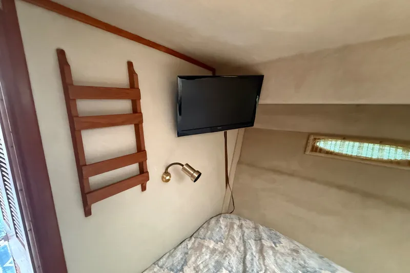 Slide: The Image of Interior of 1986 Sea Ray 410 Aft Cabin with TV, wooden ladder, and reading light. - 37