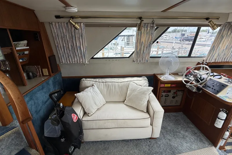 Slide: The Image of Interior of 1986 Sea Ray 410 Aft Cabin with sofa, helm, and nautical decor. - 16
