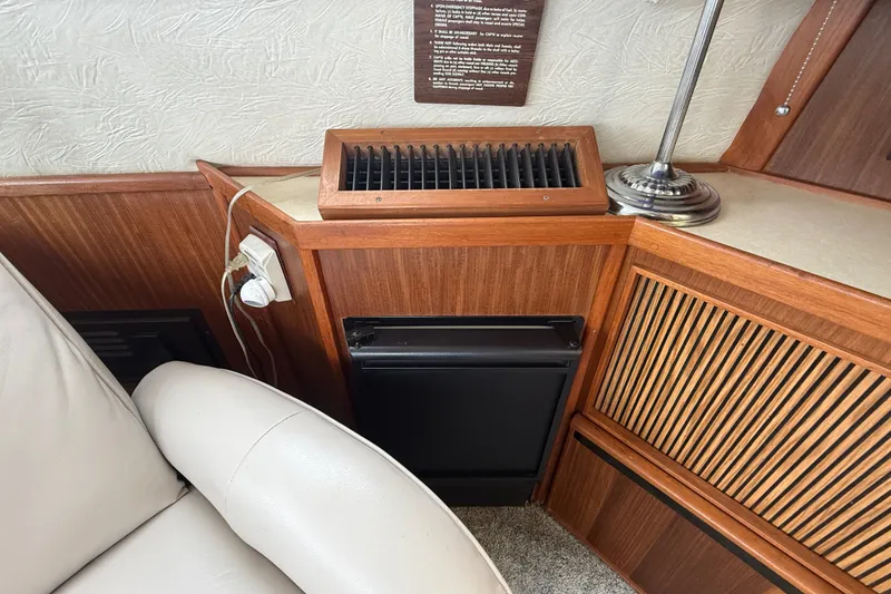 Slide: The Image of 1986 Sea Ray 410 Aft Cabin interior with wood paneling and seating area. - 20