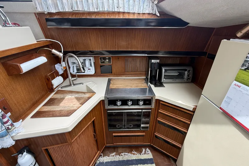 Slide: The Image of 1986 Sea Ray 410 Aft Cabin kitchen with stove, sink, and appliances. - 28
